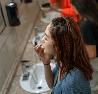 Young lady getting ready in front of a mirror